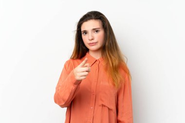 Genç esmer kız izole edilmiş beyaz arka planda hayal kırıklığına uğramış ve ön tarafı işaret ediyor.