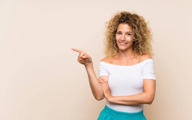 Sarışın, kıvırcık saçlı, izole bir geçmişi olan genç bir kadın.