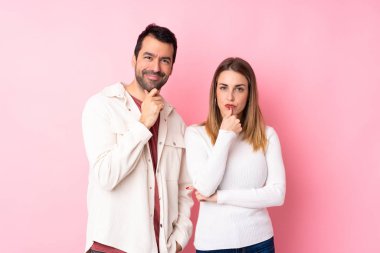 Sevgililer Günü 'nde bir çift pembe arka planda yalnız gülümseyen ve kendinden emin bir yüzle öne bakan.