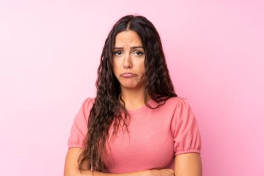 Izole pembe arka plan üzgün üzerinde genç kadın