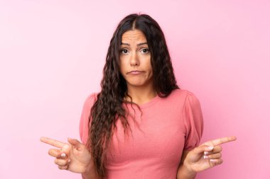 Soyutlanmış pembe arka planda genç bir kadın. Yan taraftakilerin şüpheleri olduğunu gösteriyor.