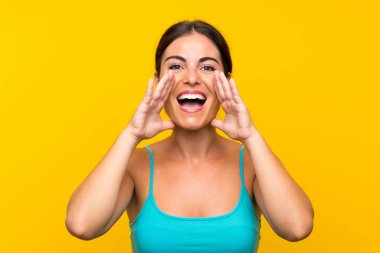 Sarı arka planda, ağzı açık bağıran genç bir kadın.