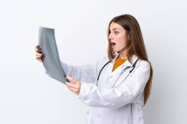 Tecrit edilmiş, doktor önlüğü giymiş ve elinde kemik taraması yapan genç bir kadın.