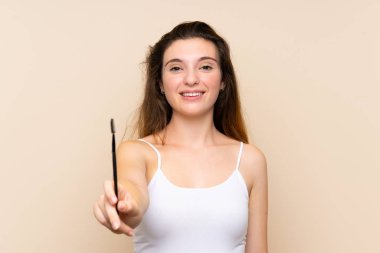 Genç esmer kız, izole edilmiş arka planda kozmetik acele ile rimel sürüyor.