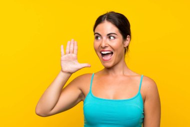 Sarı arka planda, ağzı açık bağıran genç bir kadın.