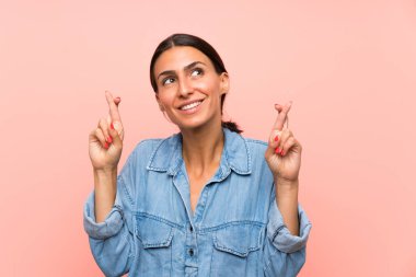 Soyutlanmış pembe arka planı olan genç bir kadın.