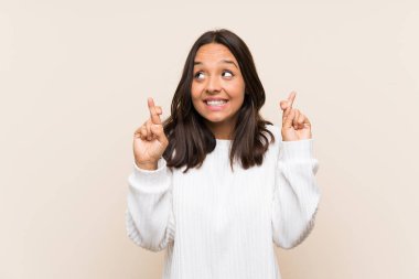 İzole edilmiş arka planda beyaz kazaklı esmer bir kadın.