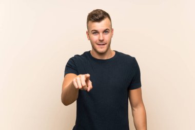 Genç, yakışıklı, sarışın, soyutlanmış, şaşırmış ve ön tarafı işaret eden adam.