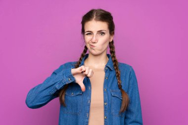 Izole mor arka plan üzerinde genç kadın başparmak aşağı işareti gösteren