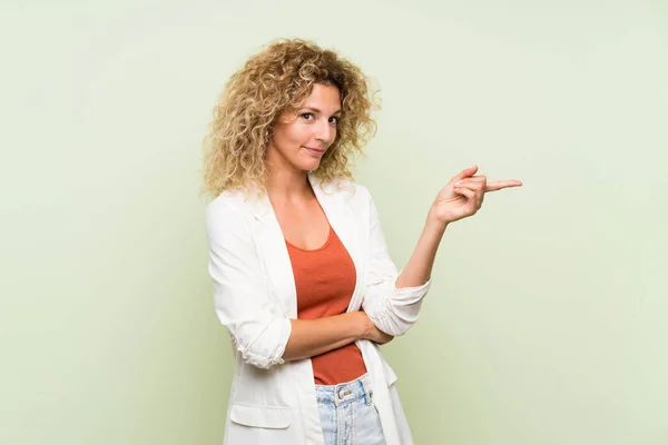 Mulher Loira Jovem Com Cabelo Encaracolado Sobre Fundo Verde Isolado — Fotografia de Stock