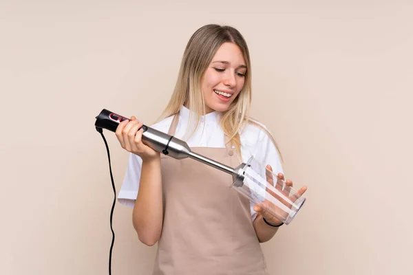 Jong blond vrouw met behulp van hand blender — Stockfoto