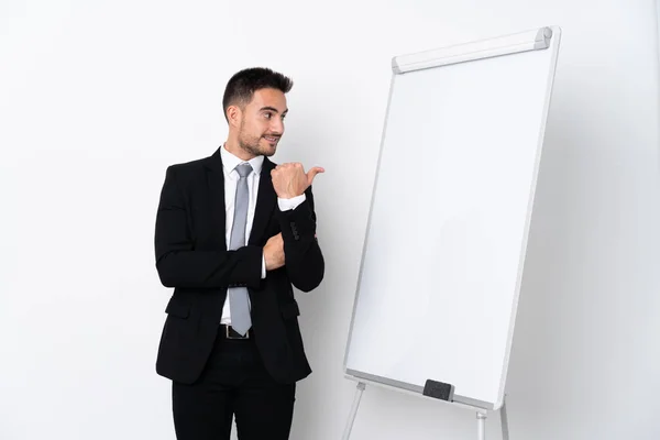 Young man giving a presentation on white board and pointing to the side