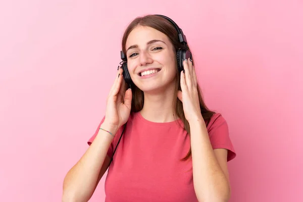 Mujer Joven Sobre Fondo Rosa Aislado Escuchando Música — Foto de Stock
