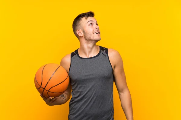Pemuda Pirang Tampan Memegang Bola Basket Atas Latar Belakang Kuning — Stok Foto