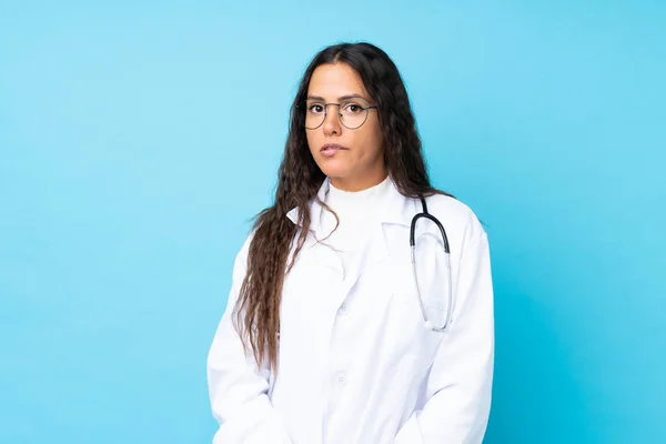 Junge Ärztin Über Isoliertem Blauem Hintergrund Mit Zweifeln Und Verwirrtem — Stockfoto