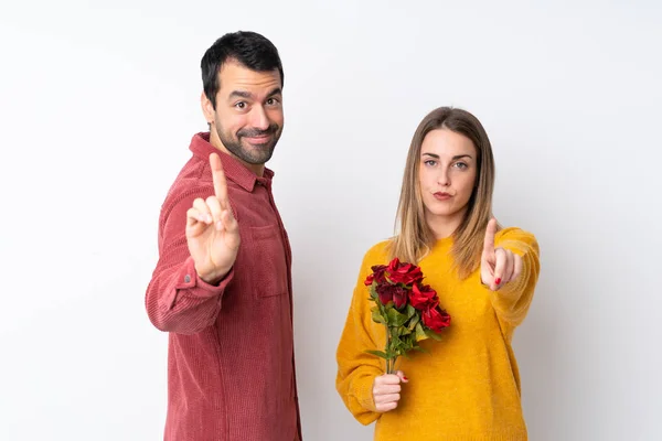 Para Walentynki Trzymając Kwiaty Odosobnionym Tle Pokazując Podnosząc Palec — Zdjęcie stockowe