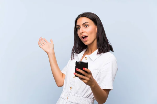 Giovane Donna Con Telefono Cellulare Oltre Isolato Muro Blu Con — Foto Stock