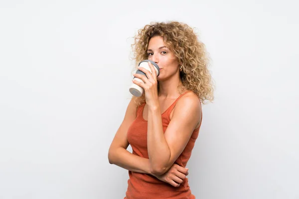 Jeune femme blonde aux cheveux bouclés tenant un café à emporter — Photo