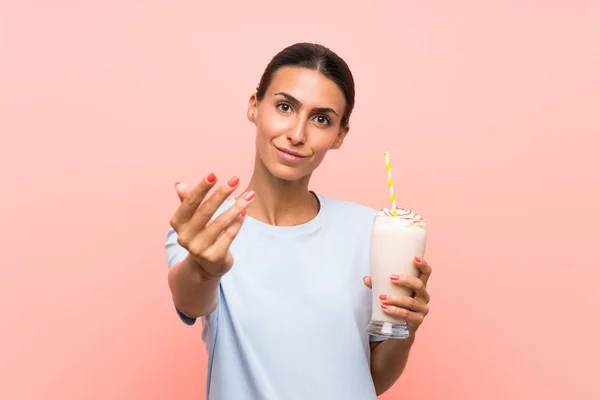 Mujer Joven Con Batido Fresa Sobre Fondo Rosa Aislado Invitando —  Fotos de Stock