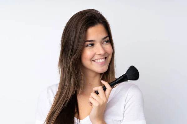 Adolescente Chica Sobre Aislado Fondo Sosteniendo Maquillaje Cepillo Mirando Hacia — Foto de Stock