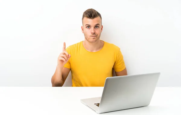 Joven Hombre Rubio Una Mesa Con Portátil Apuntando Con Dedo —  Fotos de Stock