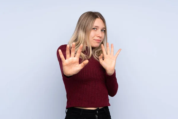 Joven Mujer Rubia Sobre Fondo Azul Aislado Nervioso Estirando Las — Foto de Stock