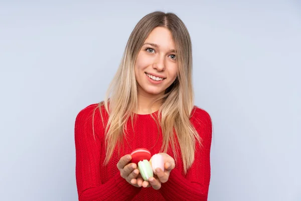 Young Blonde Woman Isolated Blue Background Holding Colorful French Macarons — 스톡 사진