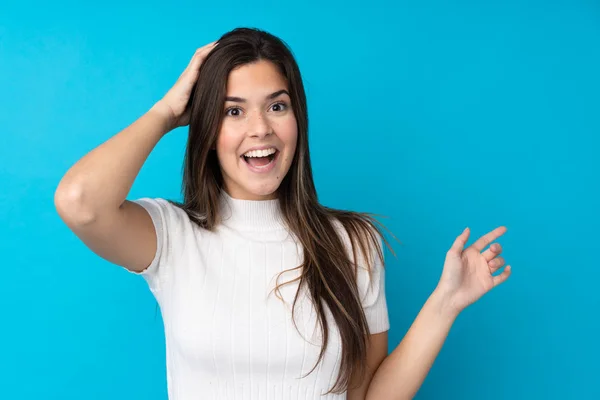 Ragazza Adolescente Isolato Sfondo Blu Sorpreso Puntando Dito Verso Lato — Foto Stock