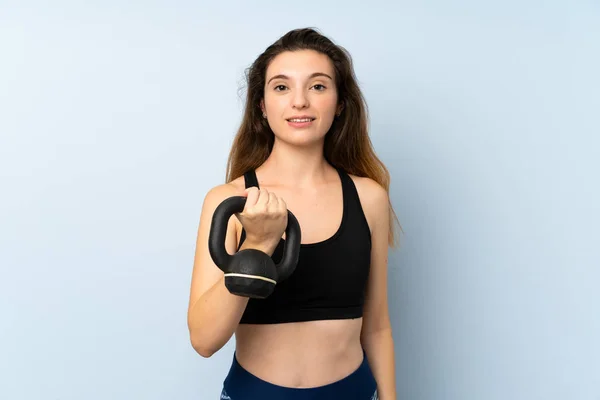 Young brunette girl making weightlifting with kettlebell over isolated background — Stock Photo, Image