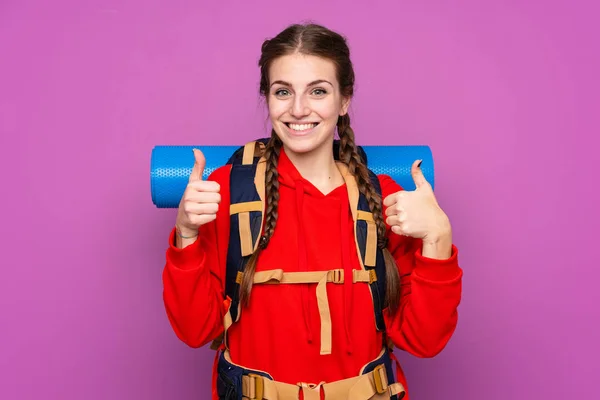 Jong Bergbeklimmer Meisje Met Een Groot Rugzak Geïsoleerde Paarse Achtergrond — Stockfoto