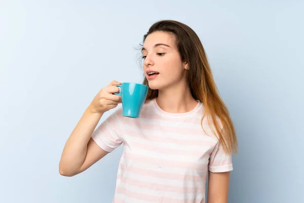 Mladá brunetka dívka drží šálek kávy přes izolované pozadí — Stock fotografie