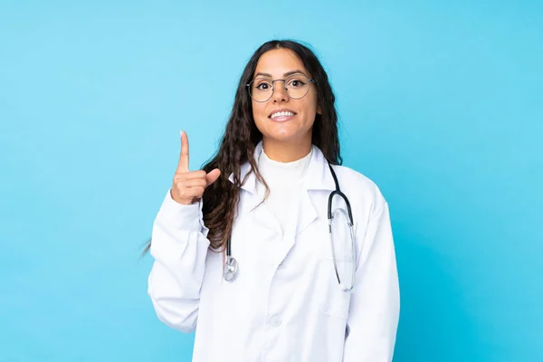 Junge Ärztin Über Isoliertem Blauem Hintergrund Die Mit Dem Zeigefinger — Stockfoto