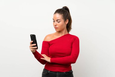 Üzgün ifade ile cep telefonu kullanan genç kadın