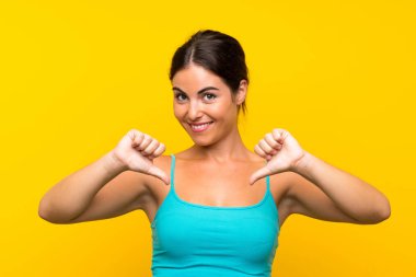 Soyutlanmış sarı arka plan gururlu ve kendini beğenmiş genç bir kadın.