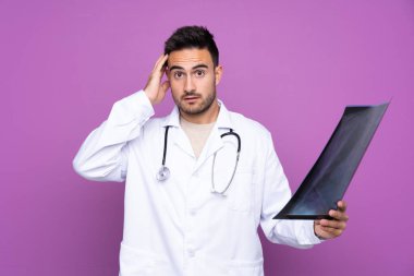 Doktor önlüğü giyen ve kemik taraması yapan genç bir adam.