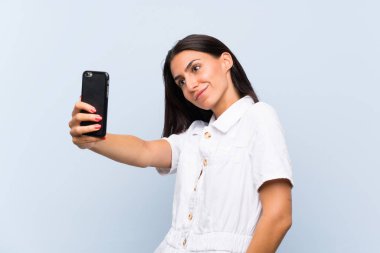 Cep telefonlu genç bir kadın selfie çekiyor.