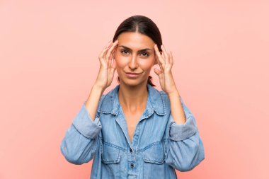 Izole pembe arka plan üzerinde genç kadın mutsuz ve bir şey ile sinirli. Negatif yüz ifadesi