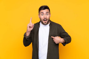 Yüzünde sürpriz ifade olan izole edilmiş sarı bir arka plan.