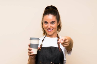 Genç bir çalışan elinde kahve puanı tutan kendine güvenen bir ifadeyle seni işaret ediyor.