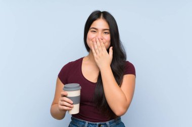 Genç Asyalı kız elinde sürpriz bir yüz ifadesiyle kahve tutuyor.