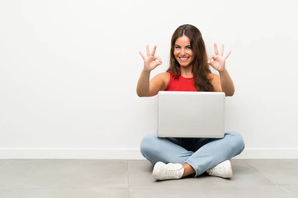 Giovane Donna Con Computer Portatile Seduto Sul Pavimento Mostrando Segno — Foto Stock