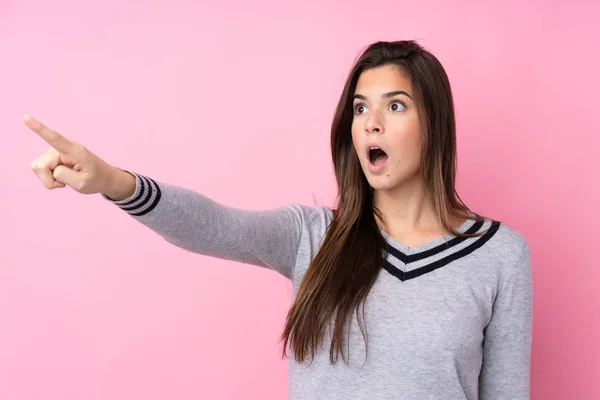 Adolescente Chica Sobre Aislado Rosa Fondo Apuntando Lejos — Foto de Stock