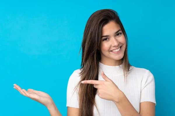 Teenager Mädchen Über Isoliertem Blauem Hintergrund Hält Kopierraum Imaginär Auf — Stockfoto