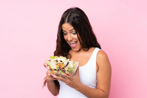 Jeune femme avec salade sur mur isolé — Photo