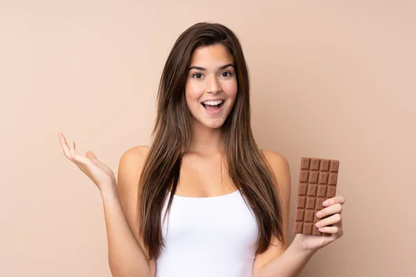 Teenager Dívka Přes Izolované Pozadí Čokoládovou Tabletu Překvapený — Stock fotografie