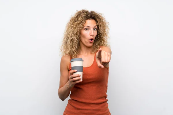 Mladá Blondýnka Kudrnatými Vlasy Drží Odnést Kávu Překvapen Ukazuje Dopředu — Stock fotografie