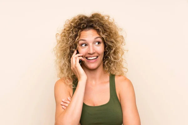 Ung blond kvinna med lockigt hår med mobiltelefon — Stockfoto