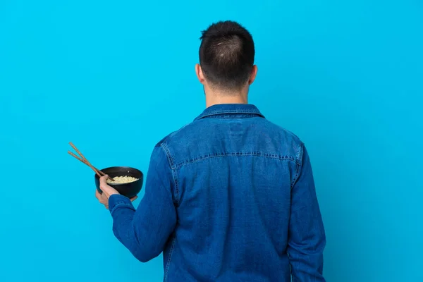 Young Handsome Man Isolated Blue Background Back Position While Holding — 스톡 사진