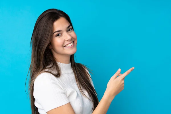 Tonårstjej Över Isolerad Blå Bakgrund Pekar Finger Sidan — Stockfoto