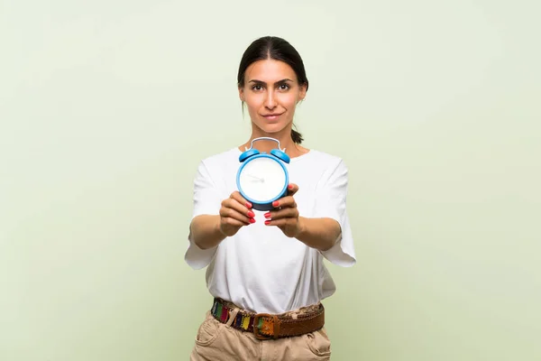 Giovane Donna Sfondo Verde Isolato Che Tiene Sveglia Vintage — Foto Stock